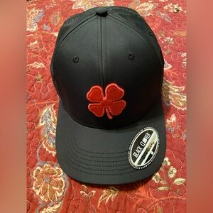 Stylish and comfortable, this cap features a bold red clover. Brand new.